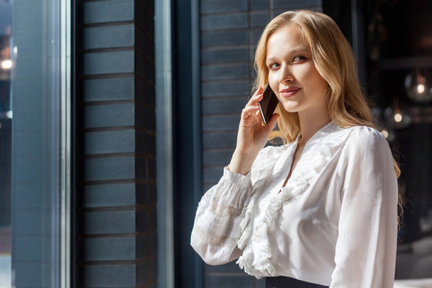 Portrait of smart devious businesswoman talking on phone and smi - Foto, imagen