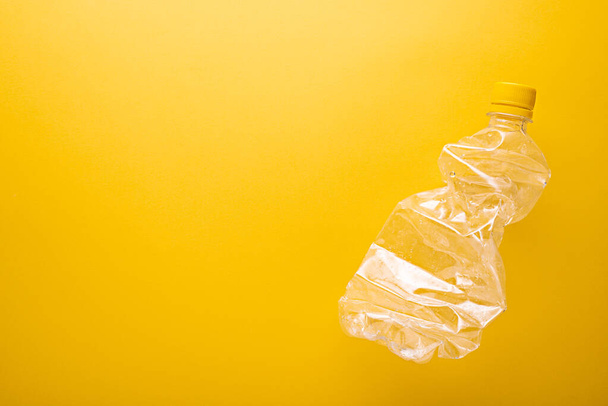 Ανακύκλωση. επάνω όψη Χρησιμοποιημένο πλαστικό μπουκάλι για ανακύκλωση με χώρο αντιγραφής, κίτρινο φόντο - Φωτογραφία, εικόνα