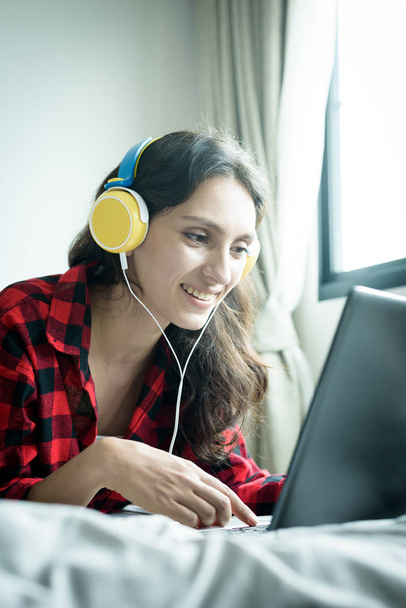 Mulher bonita trabalhando e ouvindo música em um laptop com  - Foto, Imagem