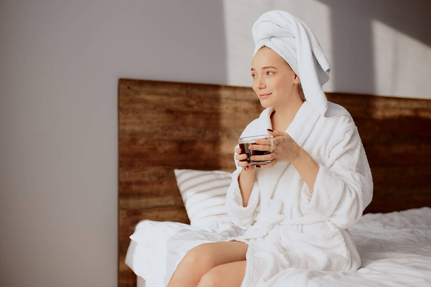 Piacevole donna che si gode il caffè in camera d'albergo
 - Foto, immagini