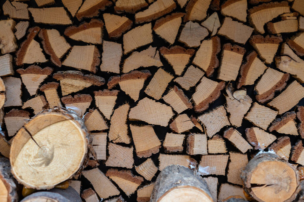 薪や丸太の切り込みの質感。薪がきれいに積み上げられている。暖かさと快適さのための暖炉用品. - 写真・画像