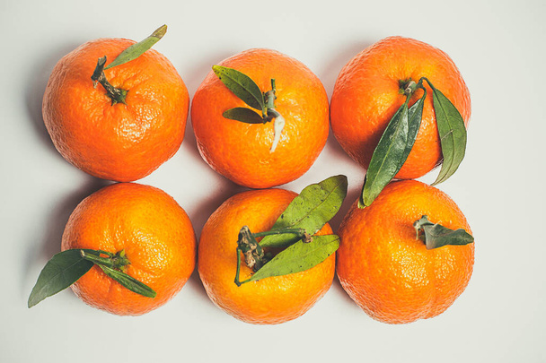 tangerinas doces de cor laranja com uma folha verde em um fundo branco
 - Foto, Imagem
