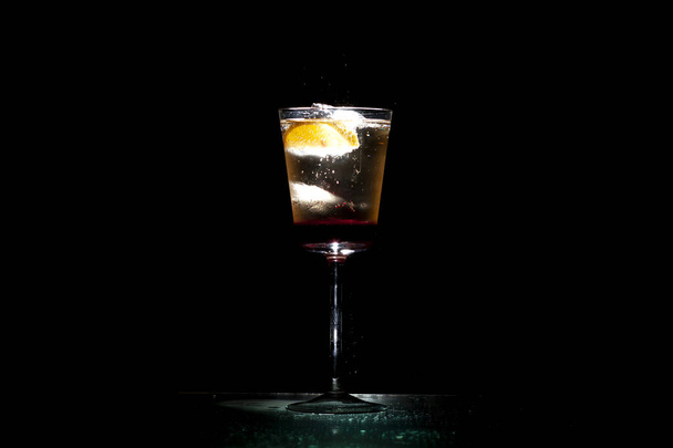 bartender makes a cocktail with champagne in a glass on a black background - Фото, зображення