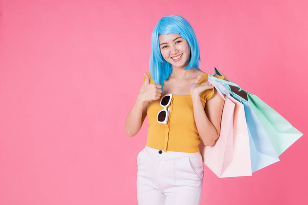 Portrait of a pretty excited asian girl with colorful shopping b - Zdjęcie, obraz