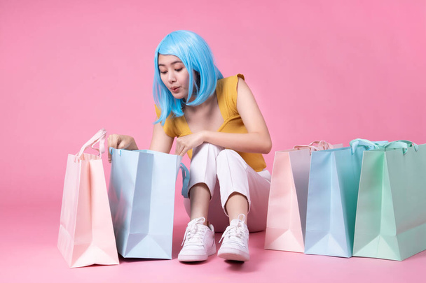 Portrait of a pretty excited asian girl with colorful shopping b - Fotoğraf, Görsel