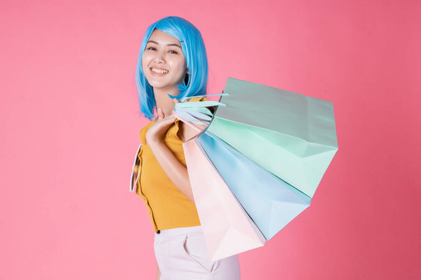 Portrait of a pretty excited asian girl with colorful shopping b - Fotoğraf, Görsel