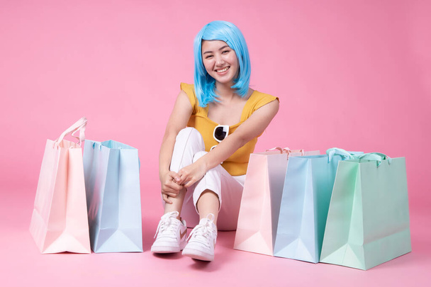 Portrait of a pretty excited asian girl with colorful shopping b - Фото, зображення