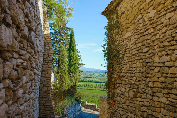 A narrow Provence street overlooking a vineyard. Sunny autumn day in Joucas. Provence tourism. - Photo, Image