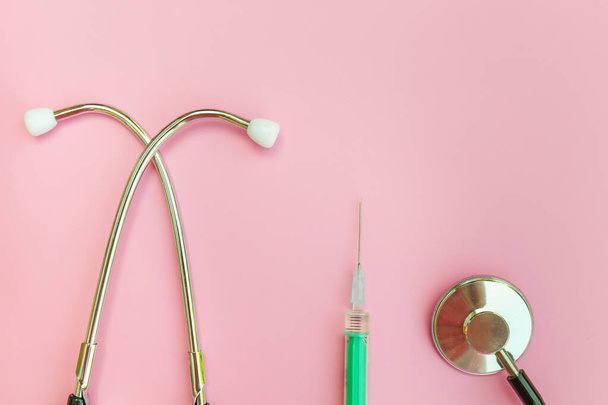 Medicine equipment stethoscope or phonendoscope syringe isolated on trendy pastel pink background - Foto, imagen