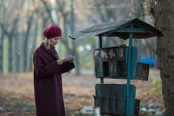 Woman takes a letter out of an old mailbox.  - Fotó, kép