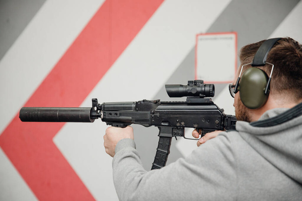 Man directs firearm gun pistol at target firing range or shooting range - Zdjęcie, obraz