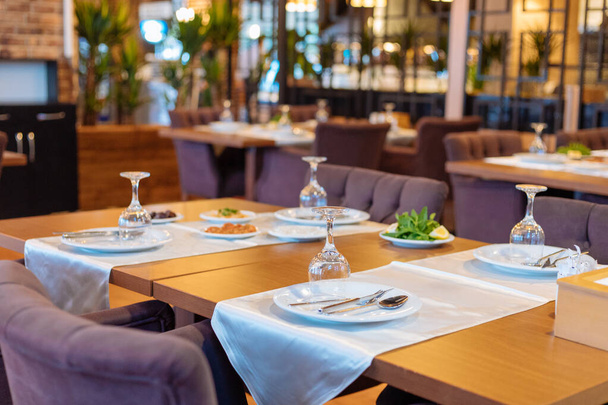 Beltéri vagy kültéri görög vagy török stílusú éttermi vacsora vagy ebéd asztal salátákkal és előételekkel. Vacsoraasztal beállítása - Fotó, kép