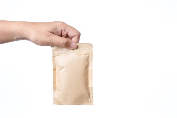Hand hält braune Papierverpackungstasche mit Reißverschluss - Foto, Bild