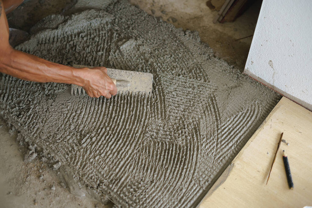 Aasian työntekijä tehdyn lattialaatat
 - Valokuva, kuva