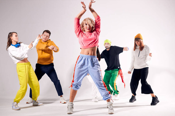 Funny men and women dancing hip-hop at studio - Foto, imagen