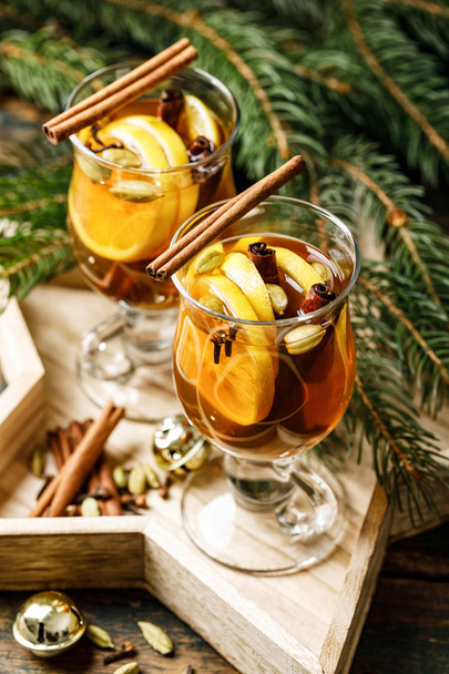 Grog. Warme drank voor de wintervakantie van het nieuwe jaar en Kerstmis. Kruidige thee en rum cocktail met citroen, kardemom, kaneel en kruidnagel. - Foto, afbeelding