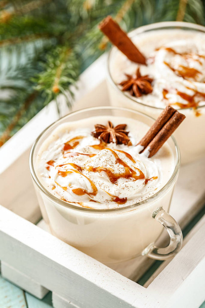 エッグノッグ伝統的なクリスマスドリンク、クリームキャラメルトッピングとスパイスの卵ミルクカクテル. - 写真・画像