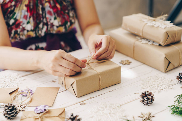 Close-up van handen houden verpakking geschenkdoos op houten tafel met - Foto, afbeelding