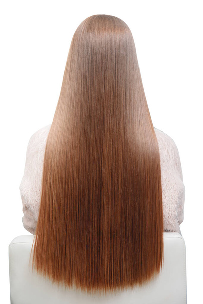 Isolated photo. Girl with beautiful long shiny smooth straight hair in hairdresser chair back. Concept Spa treatments - Photo, Image