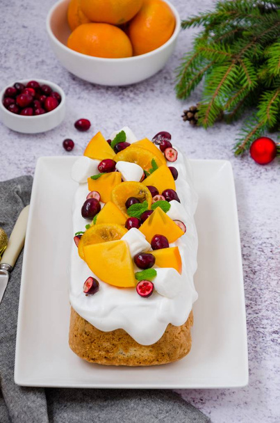 Gâteau de Noël avec glaçage à la guimauve, canneberges, kaki et mandarines caramélisées sur le dessus. Délicieux dessert festif pour Noël et le Nouvel An
. - Photo, image