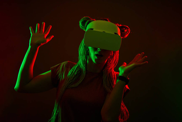 女性は仮想現実ヘッドセットを使用しています。ネオンスタジオ肖像画. - 写真・画像