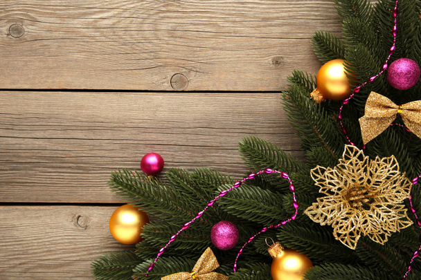 Karácsonyi dekoráció. Fenyőfa ág rózsaszín és arany golyókkal szürke alapon - Fotó, kép