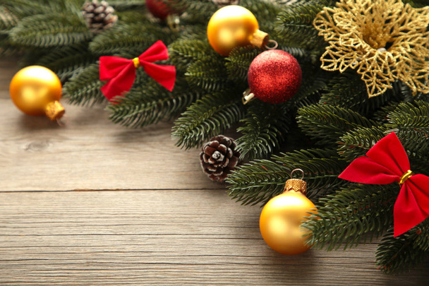 Christmas decoration. Fir-tree branch with red and gold balls on grey background - Foto, Imagem