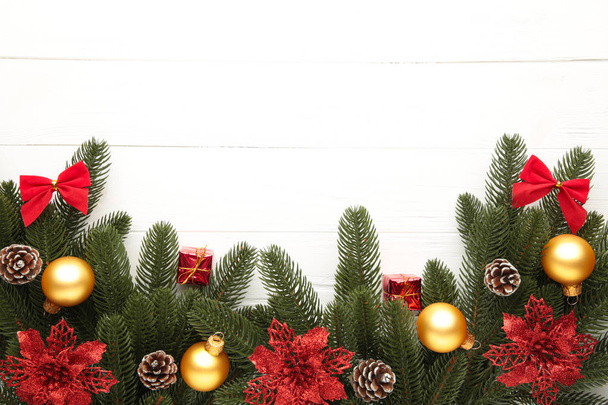 Weihnachtsdekoration. Tannenzweig mit roten und goldenen Kugeln auf weißem Hintergrund - Foto, Bild