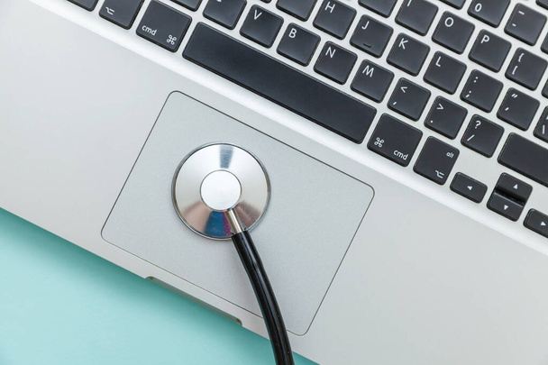 Stethoskop-Tastatur-Laptop isoliert auf blauem Hintergrund. Moderne medizinische Informationstechnologie und Software bringen das Konzept voran. Computer und Gadget Diagnose und Reparatur - Foto, Bild