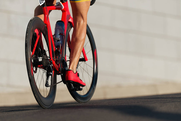 Detalle de bicicleta de carreras en ruedas de engranajes y pies
 - Foto, Imagen