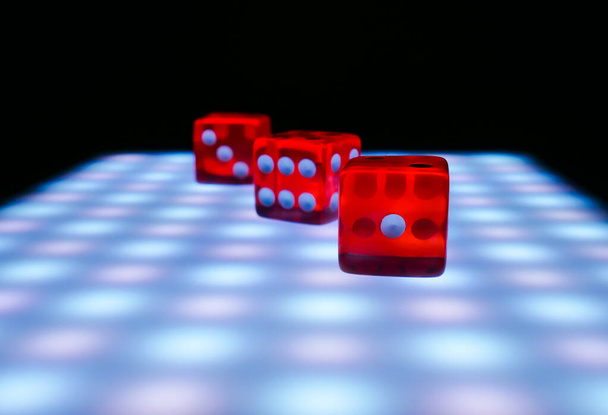 Dados vermelhos em uma mesa com luzes de néon, conepia de jogos de tabuleiro
 - Foto, Imagem