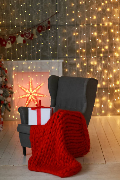Chair with red warm plaid and a box tied with Christmas ribbon - Fotoğraf, Görsel
