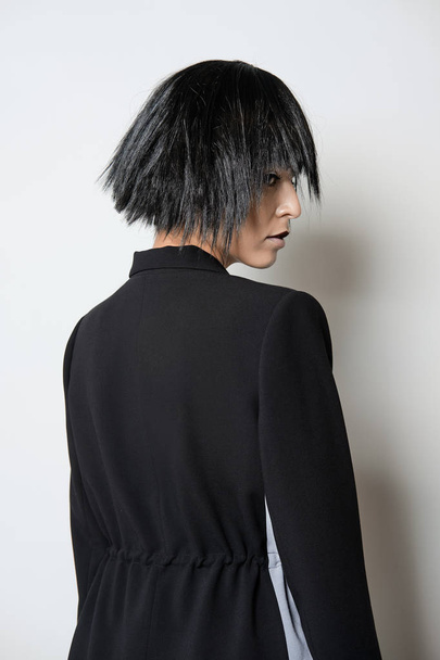 Fashion model in short black wig posing in profile - Fotó, kép