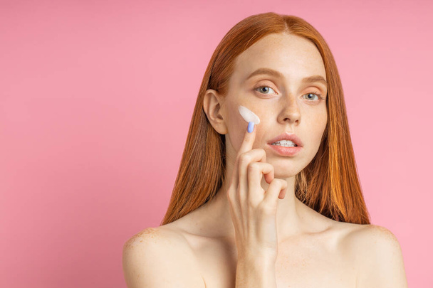 Beautiful young ginger woman with cream on face - Foto, Imagem