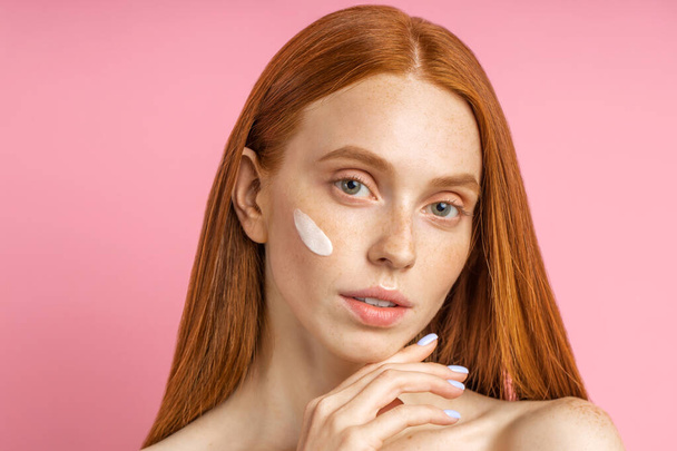 Beautiful young ginger woman with cream on face - Fotoğraf, Görsel