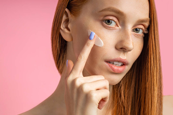 Beautiful young ginger woman with cream on face - Photo, image