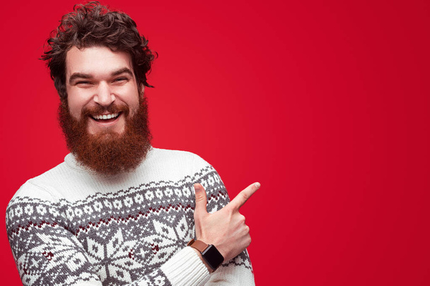 Cheerful man in sweater pointing aside - Photo, Image