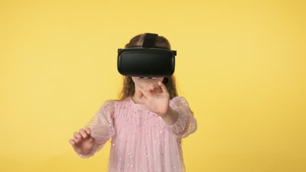 Little girl in virtual reality headset looking around in amazement. 4K, UHD - Felvétel, videó