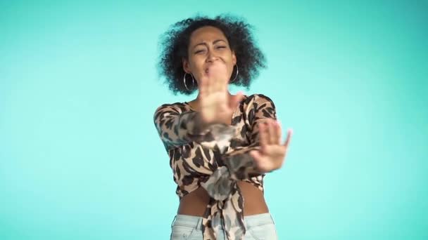 Smiling woman raising hands up to say no stop. Sceptical and distrustful look, feeling mad at someone. Afro girl facial expressions, emotions and feelings. Body language - Кадри, відео