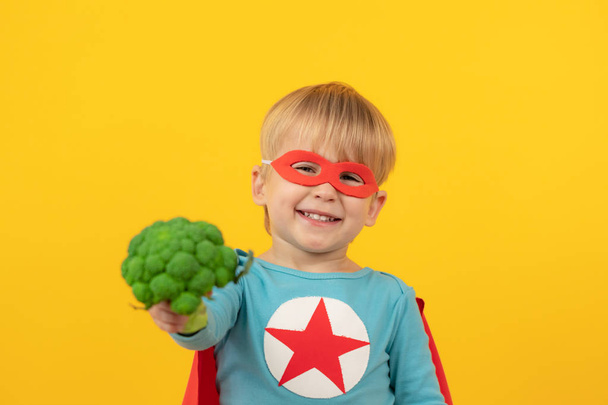 Superhero child holding broccoli - Valokuva, kuva