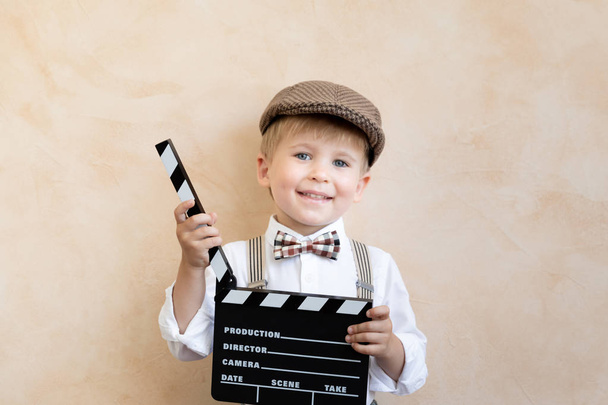 Funny kid holding clapper board - Photo, image