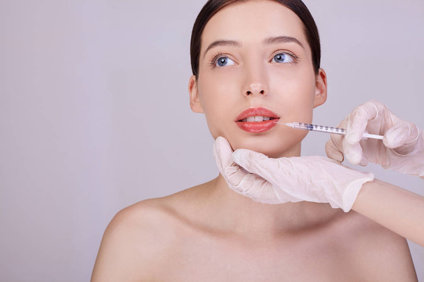 A cosmetologist makes procedures for lips girl. - Valokuva, kuva