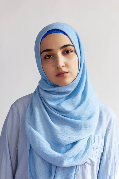 Hermosa mujer musulmana en hiyab contra fondo blanco. Retrato de una guapa mujer de Oriente Medio vestida con un vestido islámico tradicional - abaya. Chica joven con ropa musulmana con estilo
 - Foto, Imagen