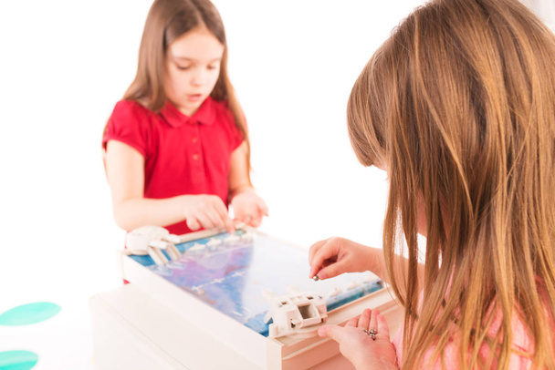 Two little girls are considering a children's game - Valokuva, kuva