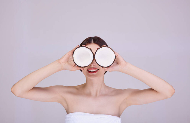 Bright brunette with coconut glasses smiles. - Photo, Image