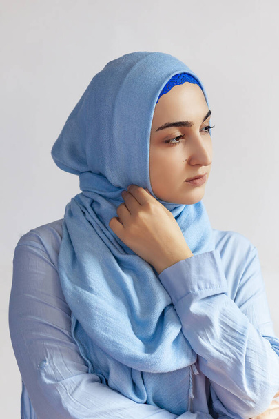 Beautiful Muslim woman in hijab against white background. Portrait of pretty middle-eastern female wearing traditional Islamic dress - abaya. Young girl in stylish Muslim clothing - Valokuva, kuva