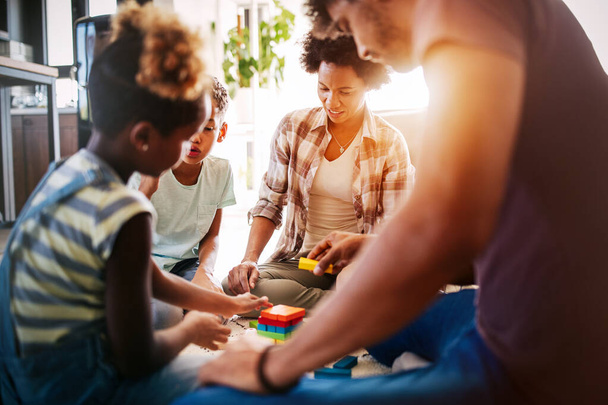 Счастливая африканская американская семья играет в игры вместе дома - Фото, изображение