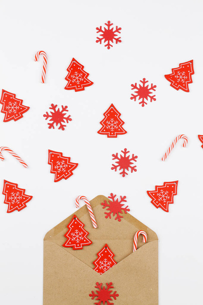 Árbol rojo de Navidad, copos de nieve y piruleta que fluyen desde el sobre sobre sobre fondo blanco
 - Foto, imagen