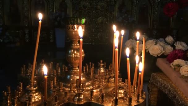 Vue sur les nombreuses bougies de cire qui brûlent sur l'autel dans la cathédrale ou l'église orthodoxe ou catholique sombre. Concept de religion et de foi Gros plan
. - Séquence, vidéo