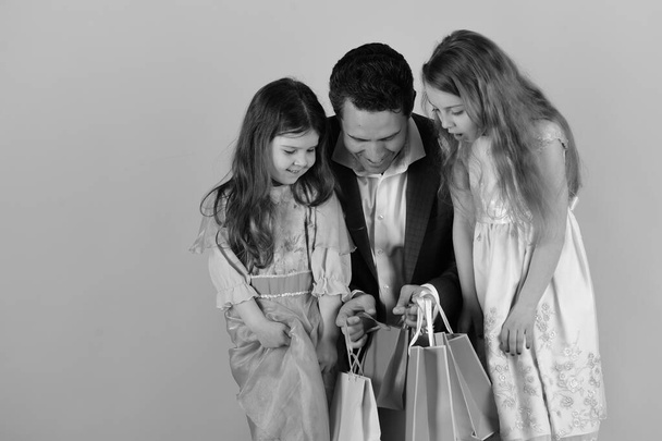 Girls and man with surprised faces hold shopping bags - Photo, Image